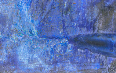 A rusty old metal plate with cracked blue gloss paint