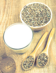 Hemp milk, seeds on wooden background . Close Up .