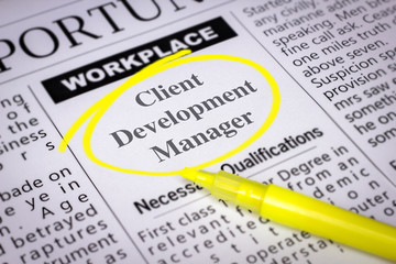 Obraz premium Client Development Manager - Newspaper sheet with ads and job search, circled with yellow marker, Blurred image and selective focus