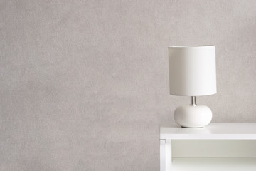 White Lamp on a commode. Grey background. Home concept