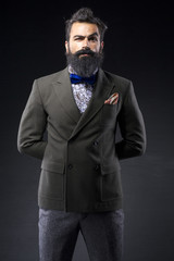 long bearded fashion man with suit on black background