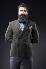 long bearded fashion man with suit on black background