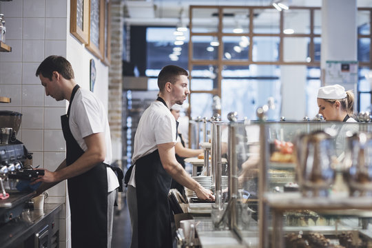 Bartenders and waitress working at coffee shop.