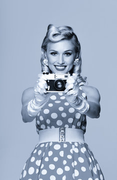 woman, with no-name camera, taking picture, dressed in pin-up style