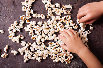 Children's hand holds popcorn 