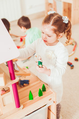 Girl playing with a dollhouse