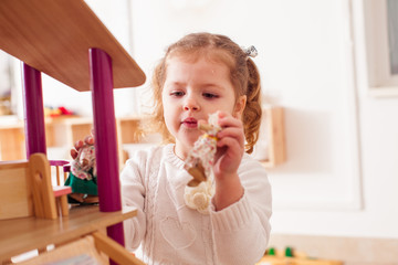 Girl playing with a dollhouse