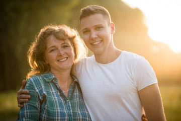 Fototapeta premium Portrait of mother and son, outdoors. Nature background.