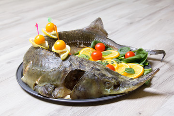 Sturgeon with oranges, spinach, cherry tomatoes and physalis . Baked whole. Selective focus.