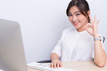 Woman use computer and make OK symbol