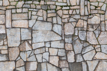 Textured gray wall with cracks and moss