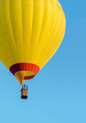 Yellow hot air balloon flying on blue sky