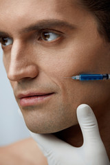 Face Beauty Treatment. Attractive Man Getting Filler Injections