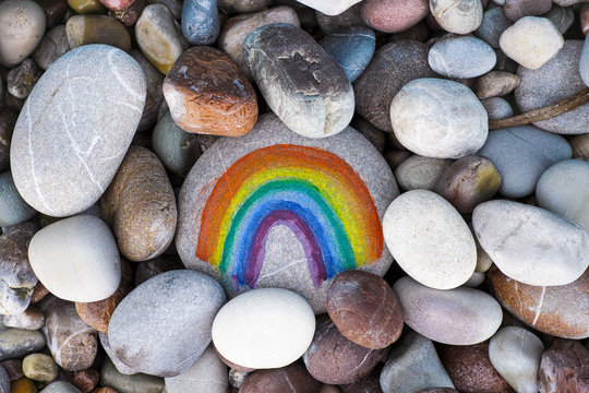 Rainbow Painted On Pebble With Stones Background