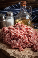 Minced meat on wooden background.