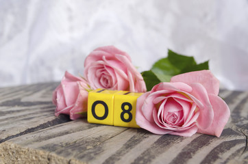 8 March symbol and roses. Figure of eight on cubes with roses on wooden background. Happy woman's day design. Can be used as a greeting card for international Woman's Day on 8 March