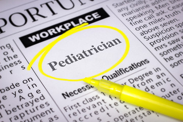 Naklejka premium Pediatrician - Newspaper sheet with ads and job search, circled with yellow marker, Blurred image and selective focus