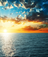 bright sunset in clouds over sea