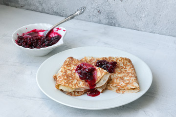 Pancakes with sweet red jam on concrete background © masterq
