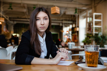 Beautiful brunette using laptop and tablet hipster coffee shop with a wooden table.