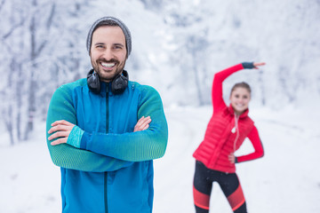 Female jogger and personal trainer stretching in the public park.