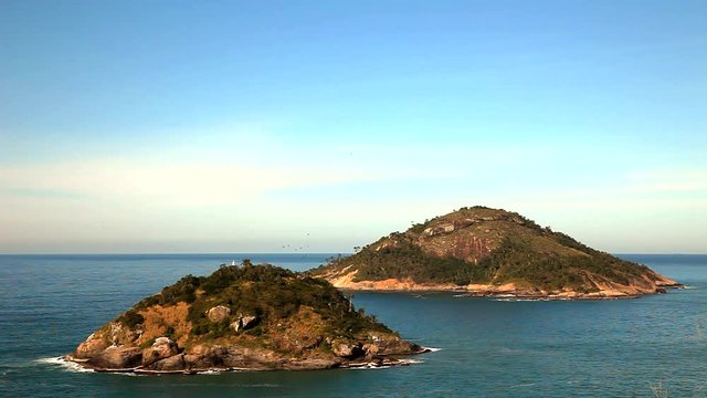 Grumari Beach is a good spot for surf and relaxes in Rio de Janeiro. View of an island with downtown on the background.