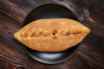 Tasty fresh homemade pie with fish on wooden background