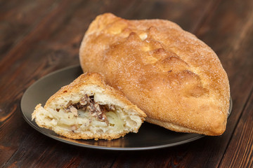 Tasty fresh homemade pie with fish on wooden background