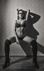 Fototapeta premium Sexy woman with wet hair posing at vintage wall, black and white
