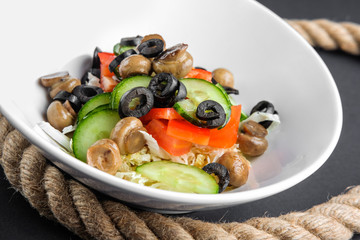 Closeup plate with salad with mushroom, olives, cucumber and pepper