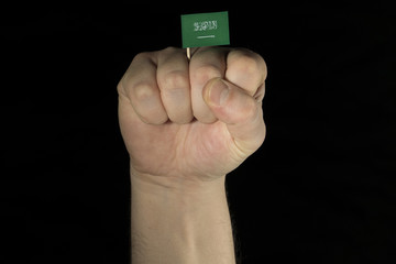 Man hand fist with Saudi Arabian flag isolated on black background