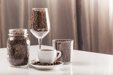 Composition of coffee beans with coffee cup, glasses and jar