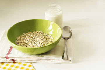 A close-up of oatmeal with yoghurt on white table. Healthy breakfast.