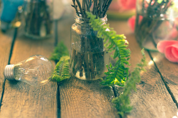 The branches in a glass jar on the background of flower on the wooden