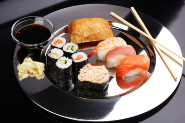 close up of sashimi sushi set with chopsticks and soy - sushi roll with salmon and sushi roll with smoked eel, selective focus - delicious maki and nigiri