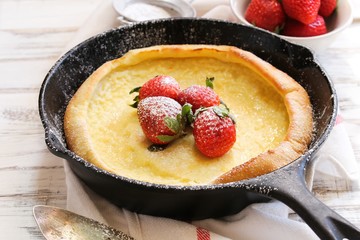 Dutch baby Puffed Pancake baked in cast iron skillet, selective focus