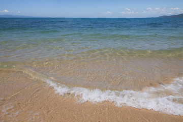 Fototapeta na wymiar wave of blue sea on sandy beach. Background.
