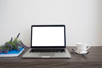 office wood  table with blank screen on notebook, coffee cup, book and purple lavender flower.