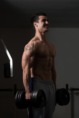 Fototapeta na wymiar Man With Dumbbells Exercising Biceps