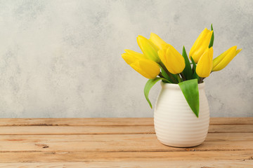 Tulip flower bouquet on wooden table over rustic background. Spring season concept