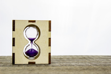 Hourglass on wooden table, on a white background