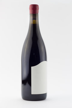Red wine bottle isolated on white - full of red wine standing upright with red wax seal over cork