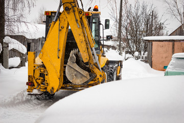 Snow clearing. Tractor clears the road after snowfall