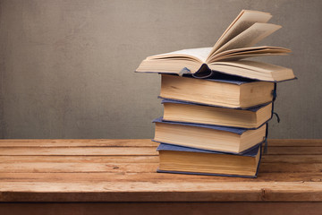 Vintage books on wooden table over rustic background. Education concept