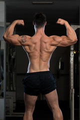 Bodybuilder Fitness Model Posing Double Biceps After Exercises