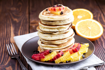 Pancake stack with oranges Wooden background 