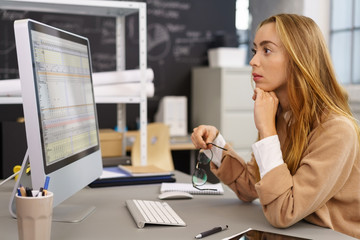 frau im büro schaut mit ernstem gesicht auf ihren computer