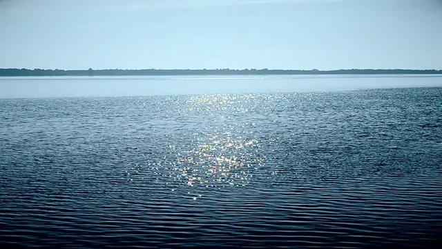 Water surface in a river or lake sparkling in the sun forming a sun way or path on water