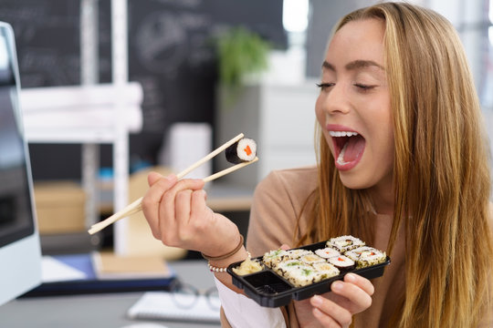 frau isst sushi im büro