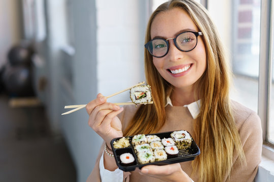 moderne junge frau isst sushi